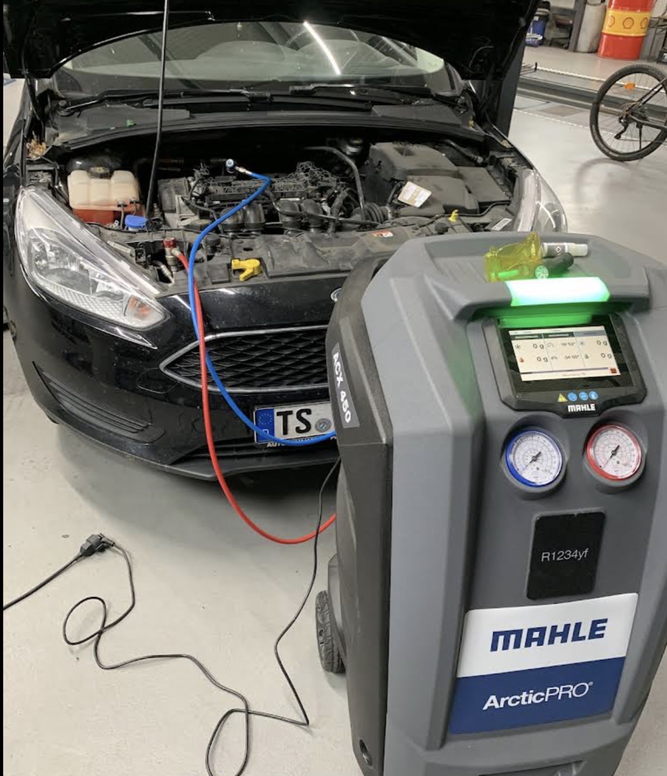 Klimaservicegerät MAHLE ArcticPRO ACX 450 für R1234yf, angeschlossen an einen schwarzen Ford mit geöffneter Motorhaube